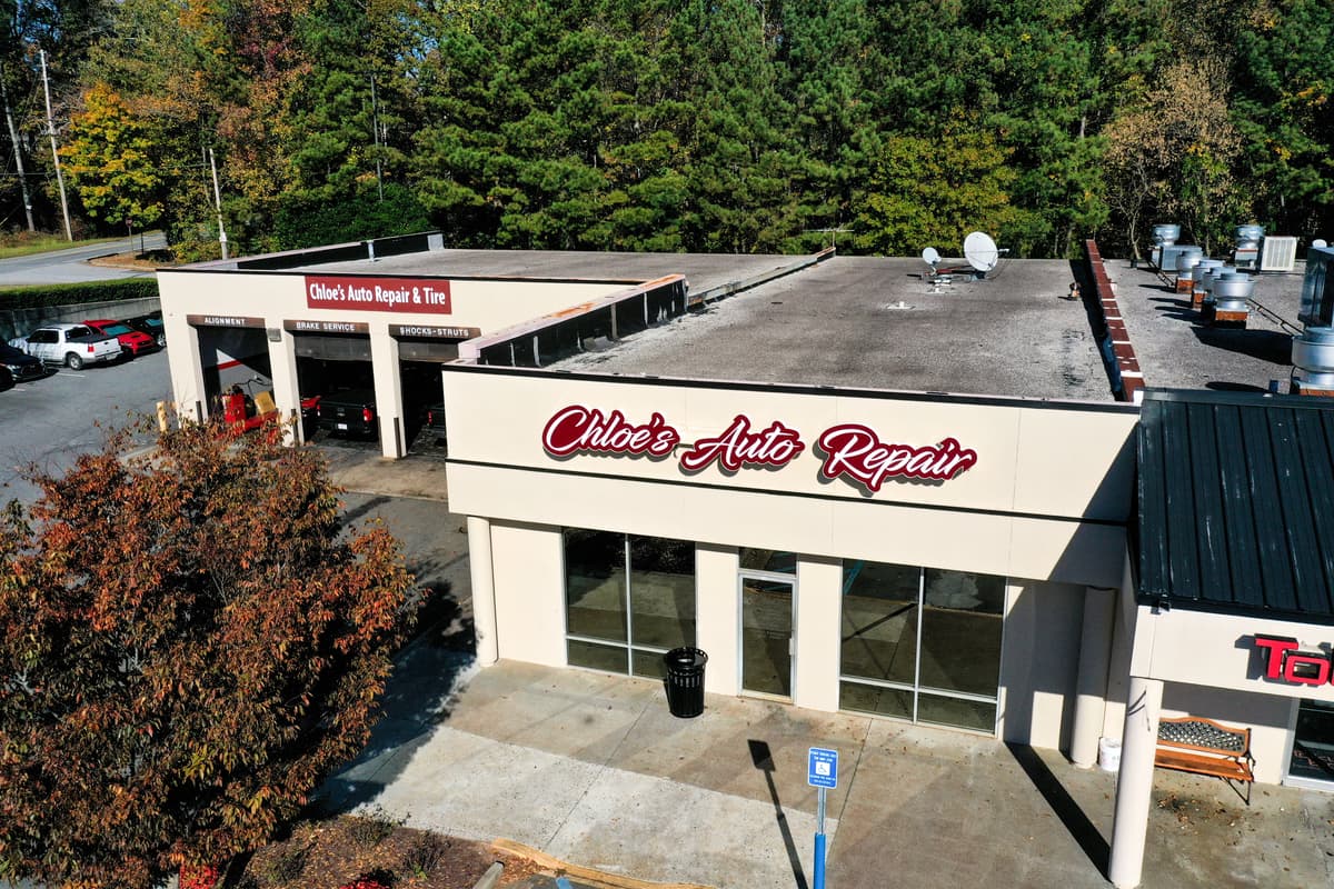 Aerial drone view of Chloe's Auto Repair & Tire facility and parking lot on Alabama Rd in Roswell, GA