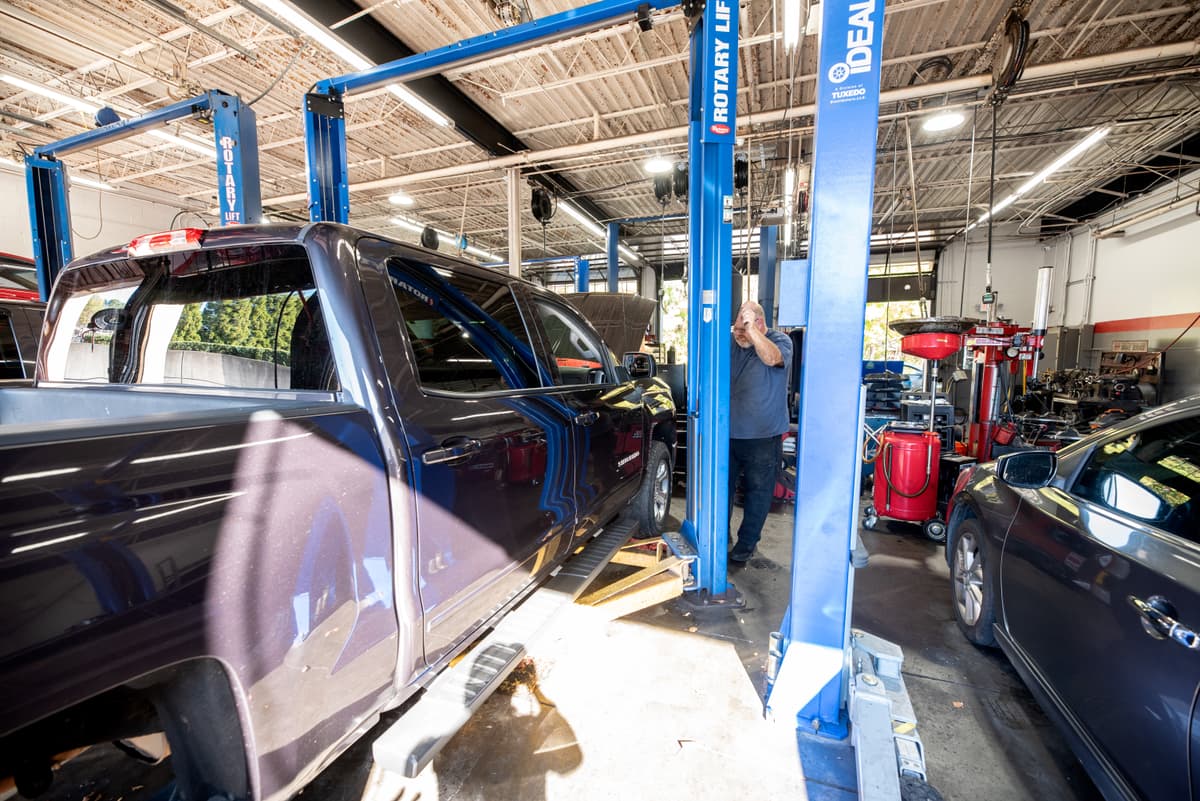 Automotive technician performing wheel alignment on a vehicle at Roswell GA auto shop